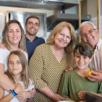 Happy family of six enjoying time together in a modern kitchen setting.