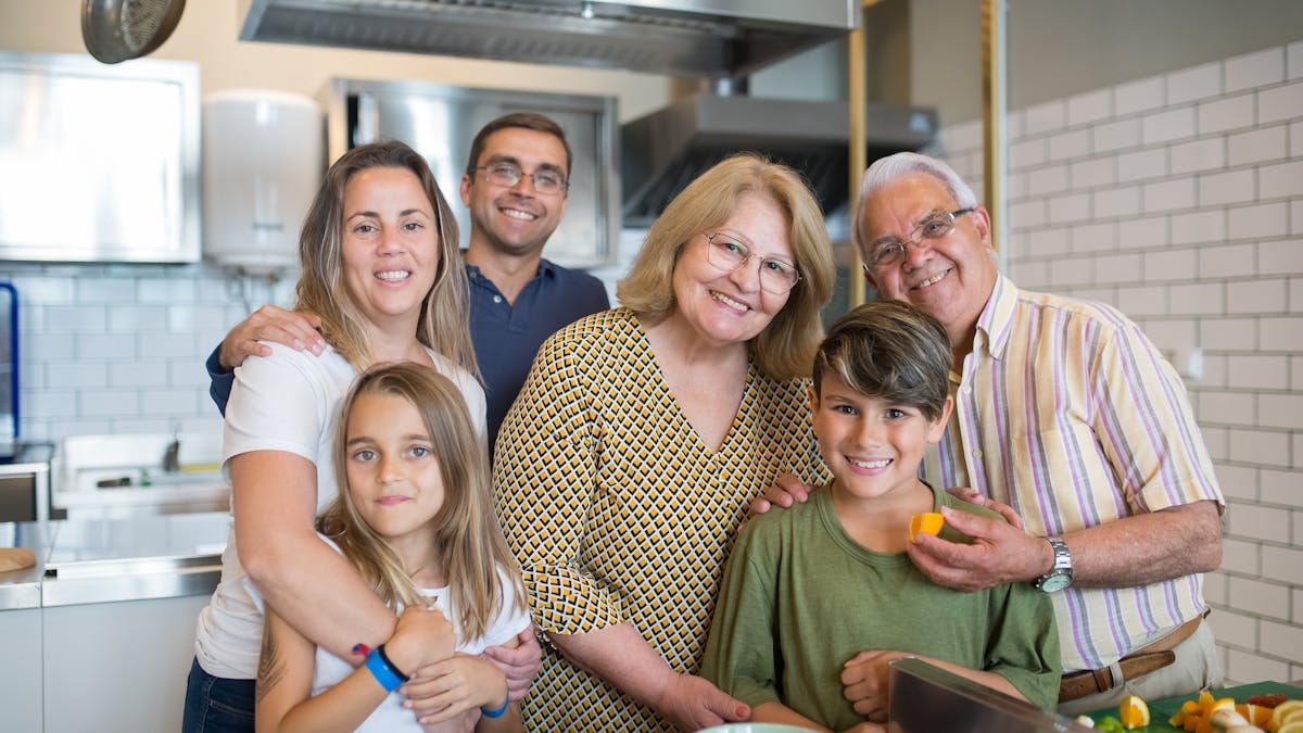 Happy family of six enjoying time together in a modern kitchen setting.