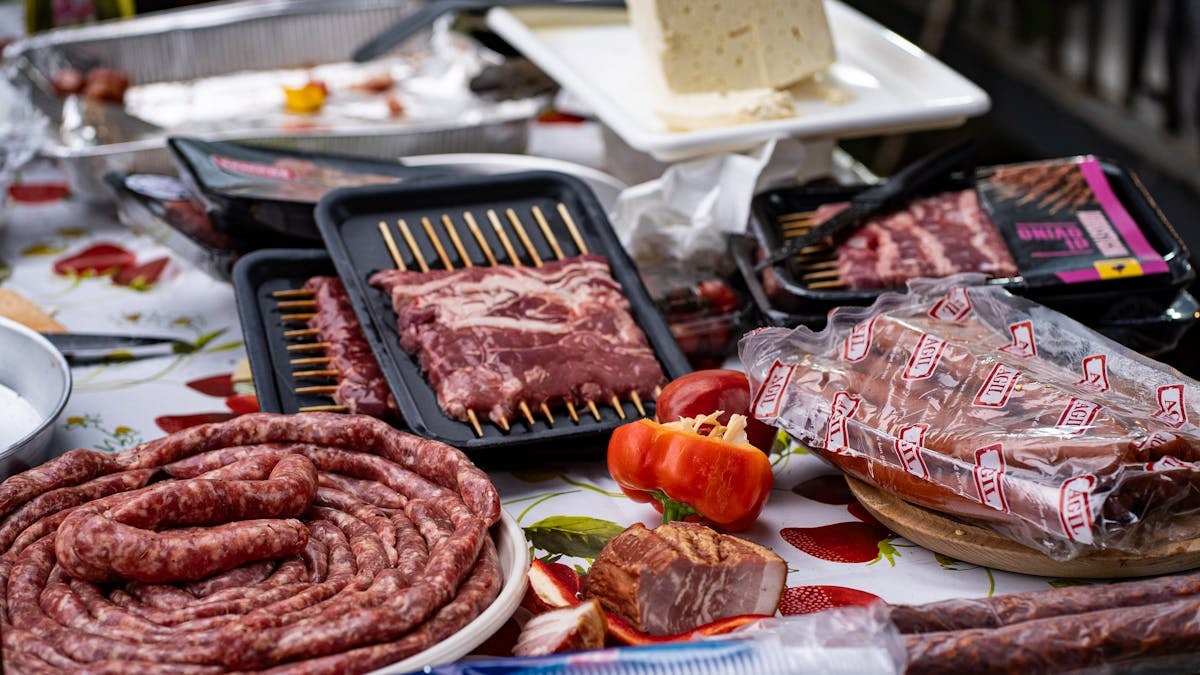 A variety of meats and vegetables arranged for an outdoor barbecue in Switzerland.